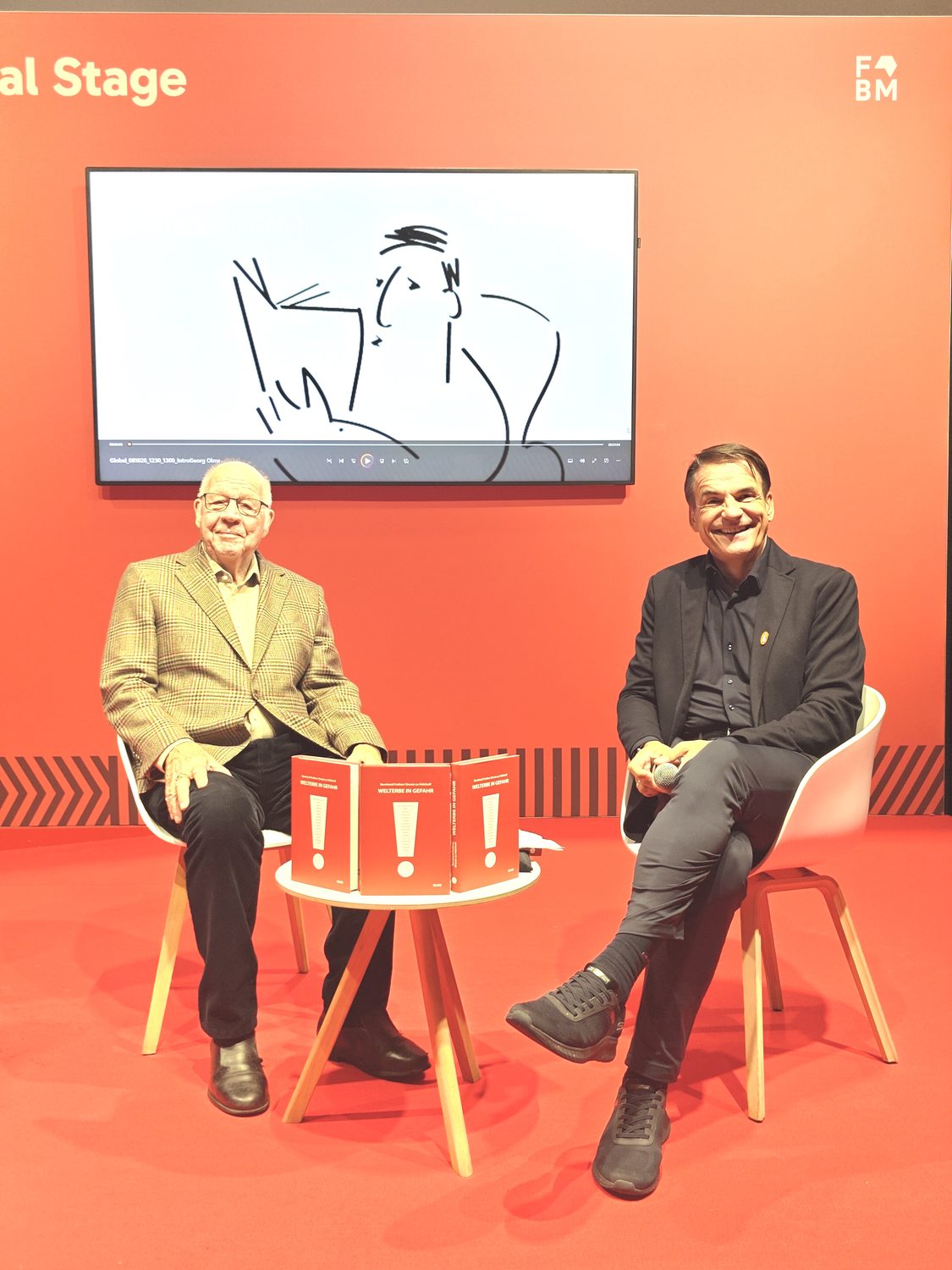 Bernd von Droste zu Hülshoff und Markus Dohle auf der Global Stage, im Hintergrund ein Kurzfilm zum Buch