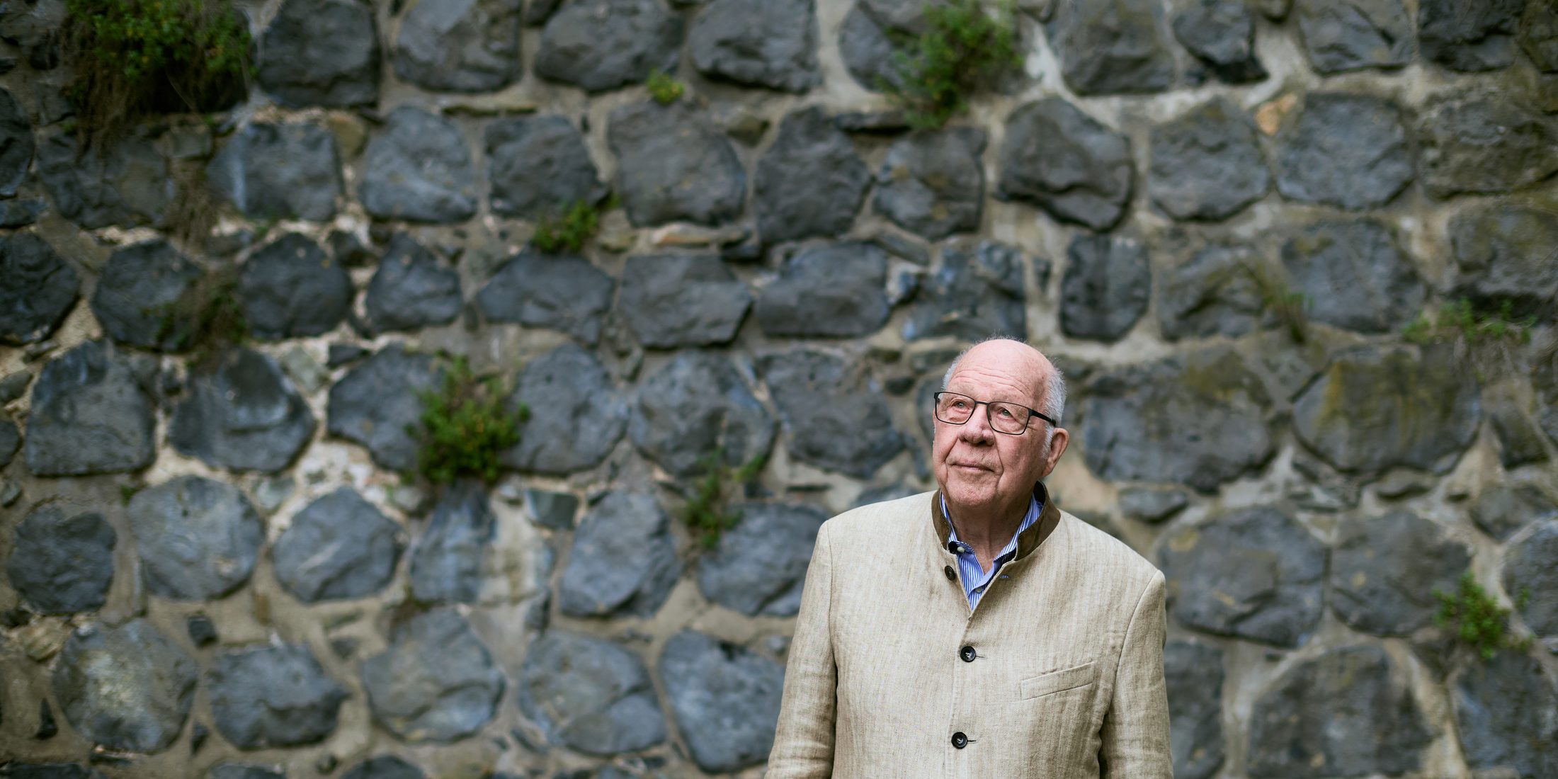 Bernd von Droste zu Hülshoff vor einer historischen Bruchsteinmauer